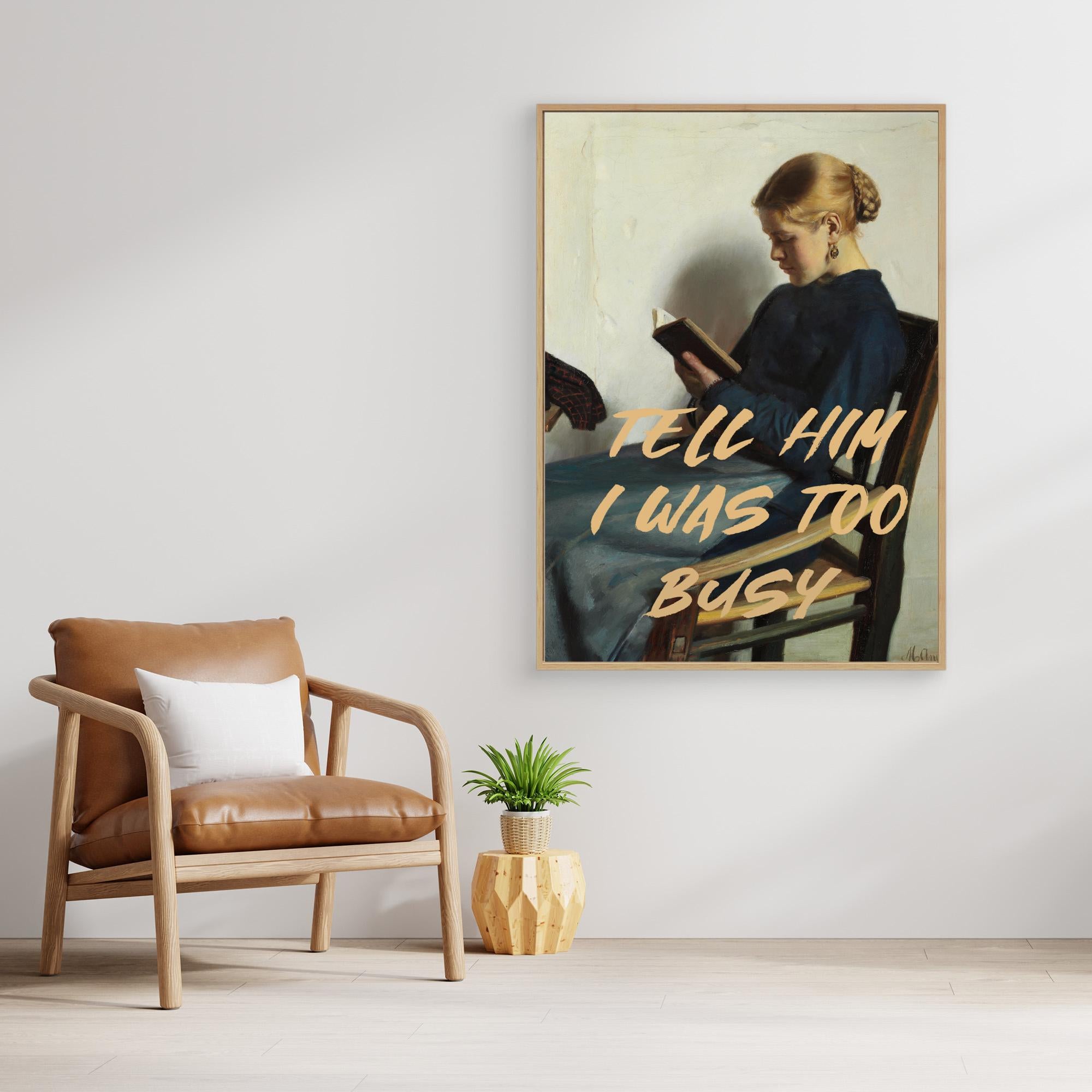 Framed artwork with text above a brown armchair in a room.